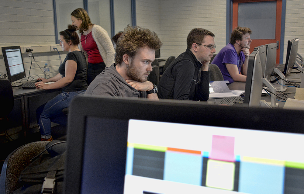 L to R Jack Walsh, Shannon Carter and Lewis Adams concentrate on editing Painted Words Submissions while Emma Burgess-Gilchrist confer in the background.