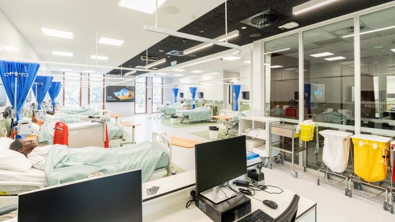 A large, bright nursing simulation laboratory designed to resemble a hospital ward