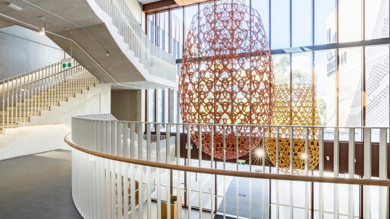 An interior shot of a modern building with a sweeping, curved staircase and white railings
