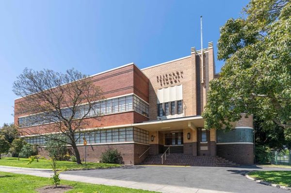 The facade of the Kangan Institute Essendon campus building, which exhibits classic red and beige brickwork and horizontal window bands