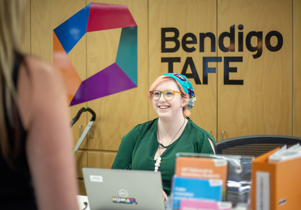 Health student seated with Bendigo TAFE logo in the background