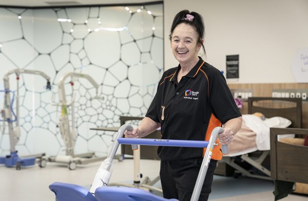 Student Nicole Atherton holding a health care support equipment in a hospital setting